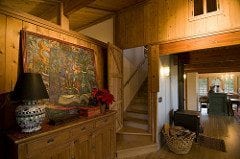 Stairs to master suite loft, with corrugated wainscotting behind woodstove.